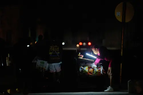 ▲古巴哈瓦那停電期間，一名小販在馬雷貢海濱大道上用電池燈照明，等待顧客。（圖／美聯社／達志影像）