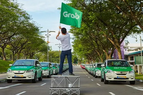 ▲男子高舉綠旗宣示主導，如同 Grab 從哈佛深夜的「MyTeksi」計畫出發，一步步在東南亞啟動的外送數位革命，終成吞併 foodpanda 的超級 App 巔峰。（圖／翻攝自Grab官網grab.com/）