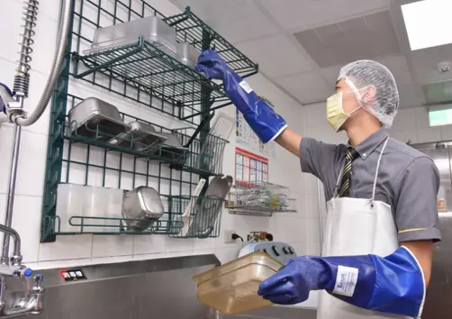 ▲麥當勞員工戴著口罩、髮網及食品級手套，正在整理廚房置物架。個人衛生防護是食品安全管理的基礎環節。（圖／麥當勞提供）