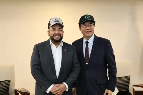 ▲ 德州達拉斯副市長莫瑞杰（左）與台南市長黃偉哲互戴對方致贈棒球帽。（圖／南市府提供）