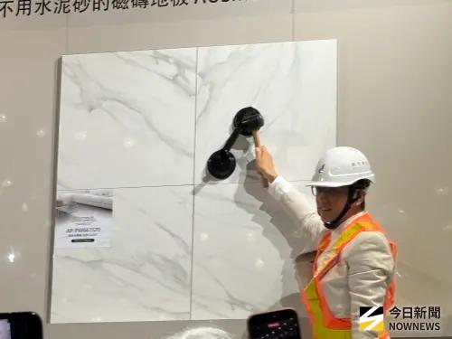 ▲許宏承現場示範卡榫式磁磚木地板，不用水泥砂，組裝方便，不僅省時、省工、減廢。（圖／記者金武鳳攝，2026.3.26)