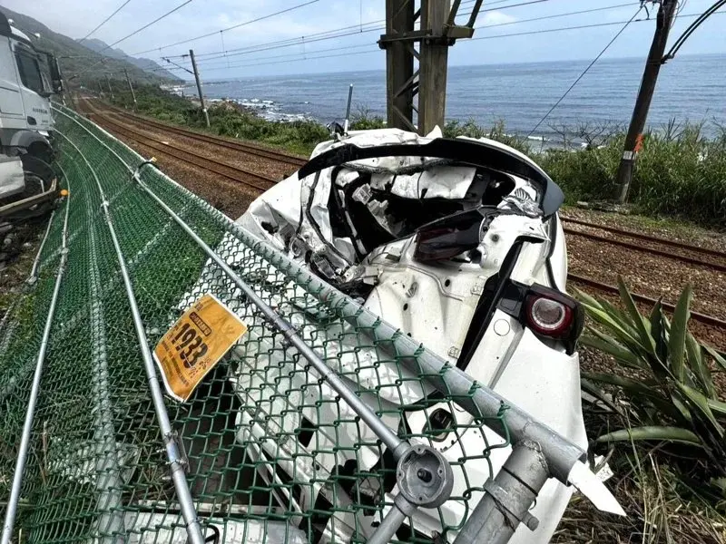 ▲宜蘭台2線貨櫃車爆胎失控連撞5車，其中一輛白色休旅車還卡在鐵軌旁邊坡。（圖／民眾提供）