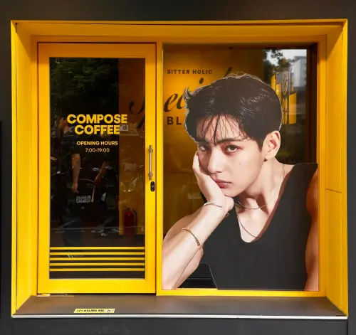▲ Compose Coffee台灣門市入口，亮黃色設計十分吸睛。玻璃窗內巨大的代言人金泰亨（V）肖像，在南京復興咖啡戰場中成為最狂打卡點。（圖／翻攝自Compose Coffee Threads）