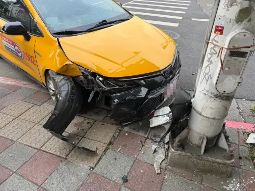 ▲計程車輾過43歲洪姓女行人的腳趾後，失控撞人行道燈桿。（圖／警方提供）