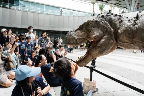 ▲高雄恐龍酷樂園正式登場，還邀請到日本擬真恐龍團隊「DINO-A-LIVE」來臺演出，圖為前日恐龍快閃高雄車站之盛況。（圖／高雄市教育局提供）