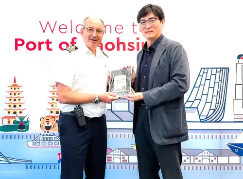 ▲高雄港務分公司處長蔡建郎(右)代表致贈首航紀念牌給島嶼天空號(ISLAND SKY)郵輪，由船長(左)代表接受。(圖／高雄港務分公司提供)