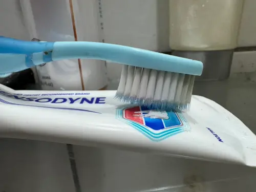 ▲牙醫師建議牙刷用完之後，要將刷毛朝下放置，輕靠在牙膏上，才可以將水分瀝乾。（圖／記者潘毅攝）