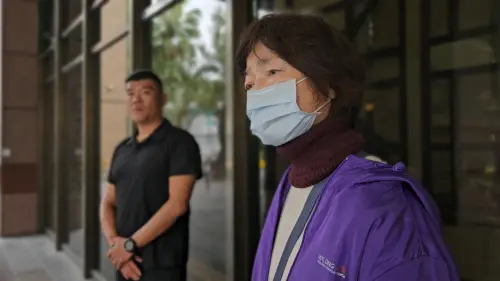 ▲林中一的姑姑林麗貞出庭受訪哭訴姪子是從小帶大的，一直以為不會被他打，如今無法原諒。身旁黑衣壯漢則是林文雄派給她的保鑣（圖／記者劉松霖攝）