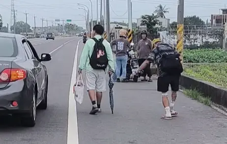 ▲前往北港的最後一哩路，有開車信眾詢問勇腳伯是否要搭車，勇腳伯仍舉起手婉謝。（圖／白沙屯媽祖全球徒步聯誼會）