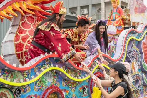 ▲《戲說台灣》演員扮演遊戲角色如財神爺、三太子、狐仙現身藝閣車，發送「紅包魚錦囊」給信眾。（圖╱網銀國際提供）