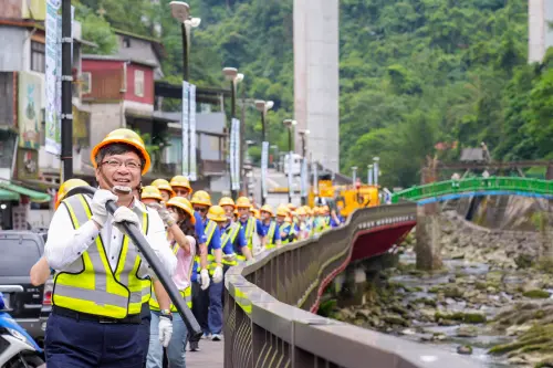 ▲台電董事長曾文生與台電同仁、現場貴賓一同體驗扛起長達60公尺、重約250公斤的電纜，親身感受台電人負重前行的辛勞。（圖 / 台電提供）