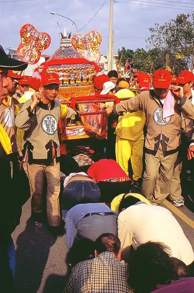 The palanquin bearers passing the palanquin over the bodies of kneeling devotees. (Taiwan Religious Culture Map / MOI Taiwan)