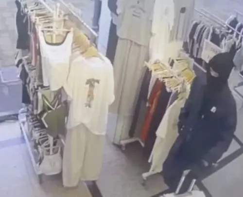 ▲24日下午北市大安中信銀行發生搶案，31歲林男持BB槍闖入行搶。案發前監視器畫面曝光，林男身穿深色連帽外套、戴黑色手套與口罩，刻意以帽子遮掩臉部，明顯有意隱藏身分。（圖／翻攝畫面）