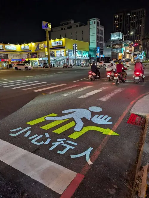 ▲系統針對右轉死角投射「小心行人」字樣，強化警示效果，不僅改善夜間視線不足問題，也降低右轉車輛視線死角風險。（圖／台南市交通局提供）