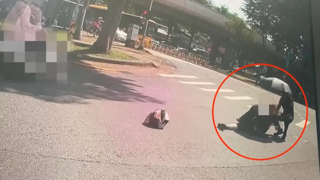 ▲台北市北投區一名沈姓女子今（29日）騎車一半突自摔，暖警見狀後上前協助並幫忙撐傘。（圖／警方提供）