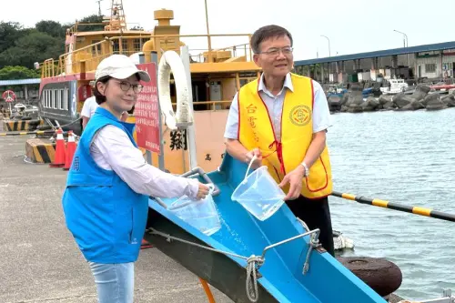 ▲台灣電力公司大林發電廠舉辦魚苗放流活動，大林發電廠廠長李志光(右)與高雄市政府海洋局股長曾莉芸(左)進行魚苗放流。(圖／台電大林發電廠提供)