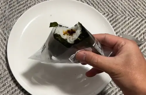 ▲日本網友dydt先將飯糰正中央的標線向下拉開，接著將一側的包裝紙拉開，再把剛拔下的塑膠套反轉，反過來套回飯糰底部當作拿取點。（圖／翻攝X@dydt_Nao）