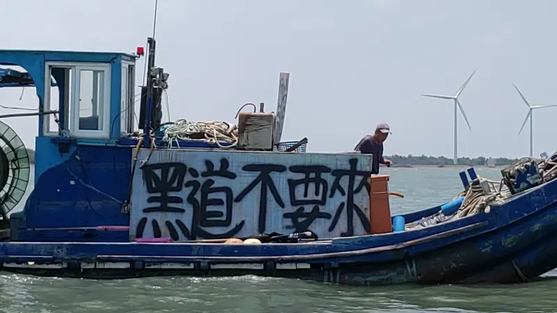    ▲李平順控訴允能風場建置時不尊重漁民，放置浮球導致漁網破損，漁民氣不過在海上集結，高掛標語控訴開發商是「黑道」。（圖／李平順提供）  