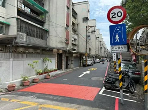 ▲新北市政府交通局近日與養工處合作，於新店區中正路117巷設置「行人優先區」，並首度在入口處導入彩色壓花瀝青鋪面。（圖／新北市政府交通局提供）