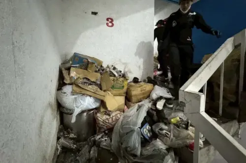 ▲桃園市南華街一處民宅4樓，因住戶長期瘋狂囤積雜物，導致樓梯間與逃生通道受阻，垃圾多到連大門都關不上。（圖／市府提供）
