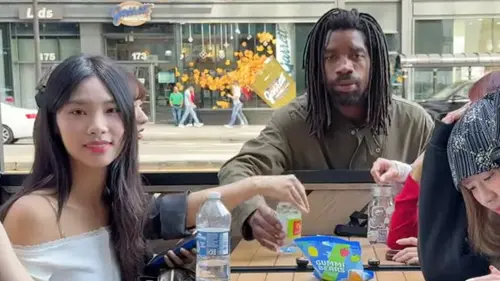 ▲陌生非裔男子隨手拿起啦啦隊女孩們桌上的水瓶。（圖／翻攝自姑娘放肆YouTube）