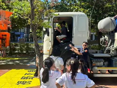 ▲高市警局交通警察大隊排學童輪流登上駕駛座體驗司機第一視角，實地體驗周遭視野死角範圍，並進行防禦駕駛模擬演練。（圖／高雄市交通警察大隊提供）