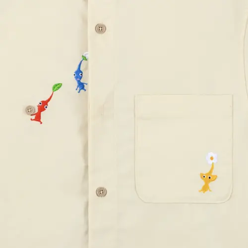 ▲任天堂將《皮克敏》經典「搬運文化」融入服飾設計，紅色皮克敏甚至直接把襯衫鈕扣搬走。（圖／Nintendo Store）