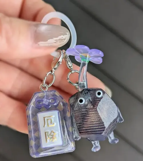 ▲岩石皮克敏搭配「厄除御守」的組合在社群爆紅，不少網友大讚細節超用心，「連御守含義都搭配好了」。（圖／IG @sugarvine_pikminbloom）