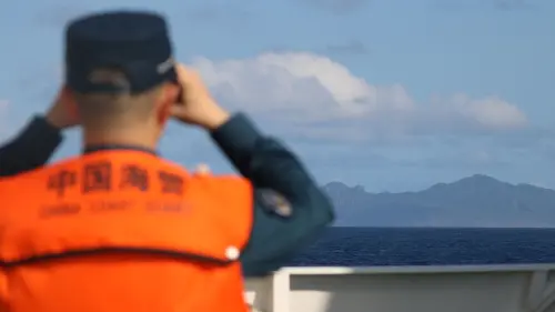 A China Coast Guard officer observes the Diaoyu Islands from aboard a patrol vessel. (CCG)