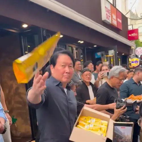 ▲SK會長崔泰源跟著黃仁勳一同發餅乾，隨手用丟的被韓國網友怒轟：「是在餵狗？」（圖／翻攝自Threads）