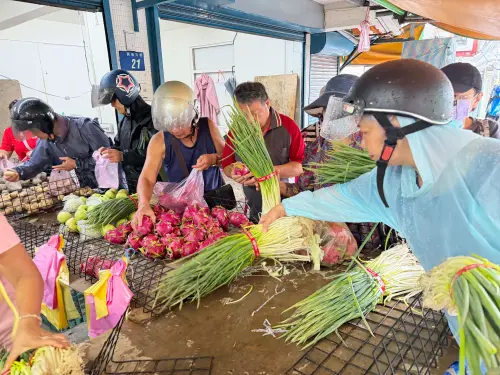 ▲市場收攤前出現拋售價格，一大把青蔥只要50元，吸引民眾一口氣搶拿多把。（圖／記者周淑萍攝）