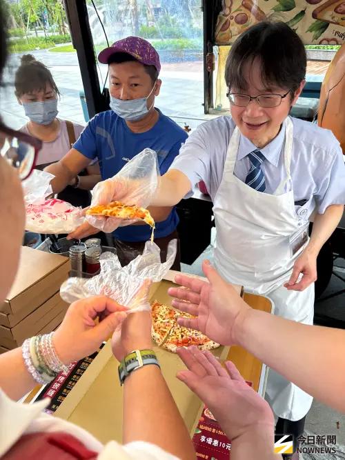 ▲張坤正院長體驗一日店長，親手製作窯烤披薩，民眾爭著品嚐，大讚院長手藝。（圖／記者金武鳳攝，2026.6.28)