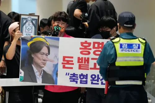 ▲更有部分激進球迷抬出畫有韓國足協徽章的黑白遺照、高掛「洪明甫吐出20億年薪再滾」的橫幅，甚至有人自備球場應援鼓，在現場瘋狂敲擊並大喊「洪明甫下課」、「滾出去！」（圖／美聯社／達志影像）