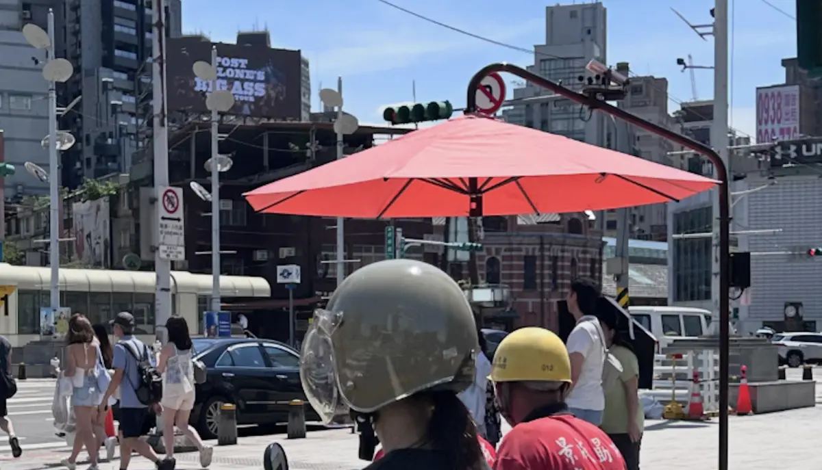 ▲高雄市近日在捷運凱旋站、凹子底站及輕軌轉乘路口設置大型遮陽傘，近日有網友發現，台北市也已在西門町捷運站出口附近設置外型相似的智慧電動遮陽傘。（圖／翻攝自Threads@postlife）