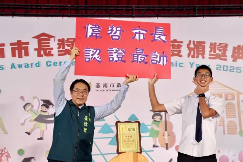 ▲ 黃偉哲與寫有「偉哲市長認證最帥」的手板的學生合影。（圖／南市府提供）
