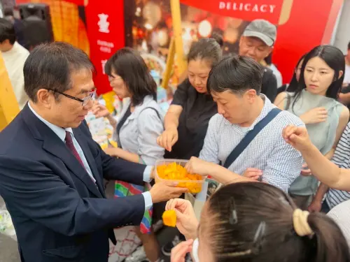 ▲ 黃偉哲於首爾弘大商圈現場請參與民眾試吃芒果。（圖／南市府提供）