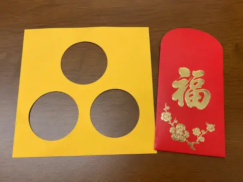 ▲ 小暑時可以準備一張黃色的紙，在黃紙上剪三個圓圈代表太陽，並放入紅包袋中，接著再放進皮夾三天。（圖／AI生成）