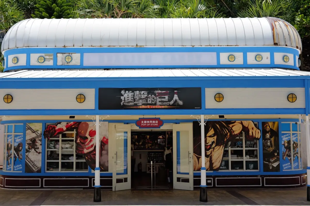 ▲遠雄海洋公園《進擊的巨人》主題快閃商店換上聯名外觀，入口兩側可見超大型巨人與進擊的巨人視覺迎接遊客。（圖／記者林若瑋攝）