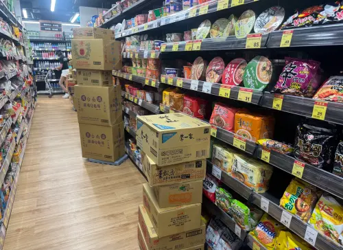 ▲賣場內也可見大量待補貨的紙箱堆放在走道旁，店員忙著將商品補上貨架，因應持續湧入的採買人潮。（圖／記者鍾怡婷攝）