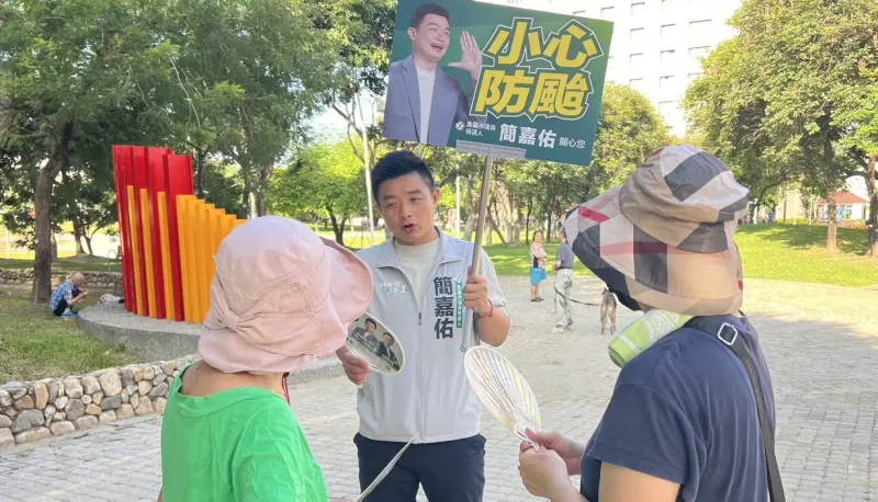    ▲民進黨北區新人簡嘉佑舉著「小心防颱」的手舉牌，到公園和長輩們尬聊。（圖／簡嘉佑，2026.07.09）  