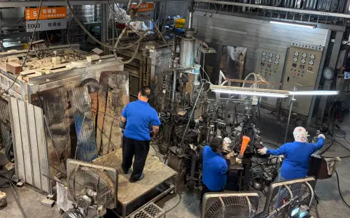 Three Spring Pool employees work together to create glass bottles. (TCN)