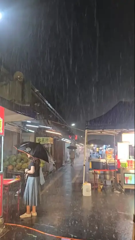 ▲台東觀光夜市下起暴雨，不少攤商穿著雨衣、加強固定攤位，遊客則紛紛撐傘或躲進騎樓避雨。（圖／翻攝自Threads@__meow28__）