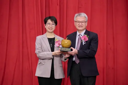 ▲財團法人中山醫學大學董事長周英香(左)致贈校園桃花心木雕製的蘋果紀念藝品予卸任校.（圖／中山醫大提供）