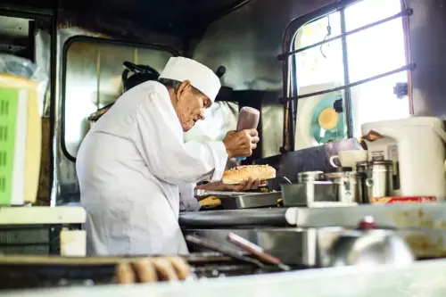 ▲今崎勝美爺爺長期屈身在狹小餐車裡工作，駝背身影成為漢堡仙人標誌。（圖／今屋漢堡imayahamburger.com）