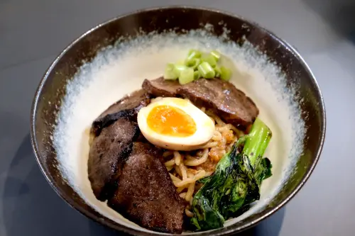 ▲「炙燒和牛臉頰拌麵」的醬汁疊加許多滋味，以多塊牛臉頰肉配上山茶花粗捲麵。（圖／記者葉盛耀攝）