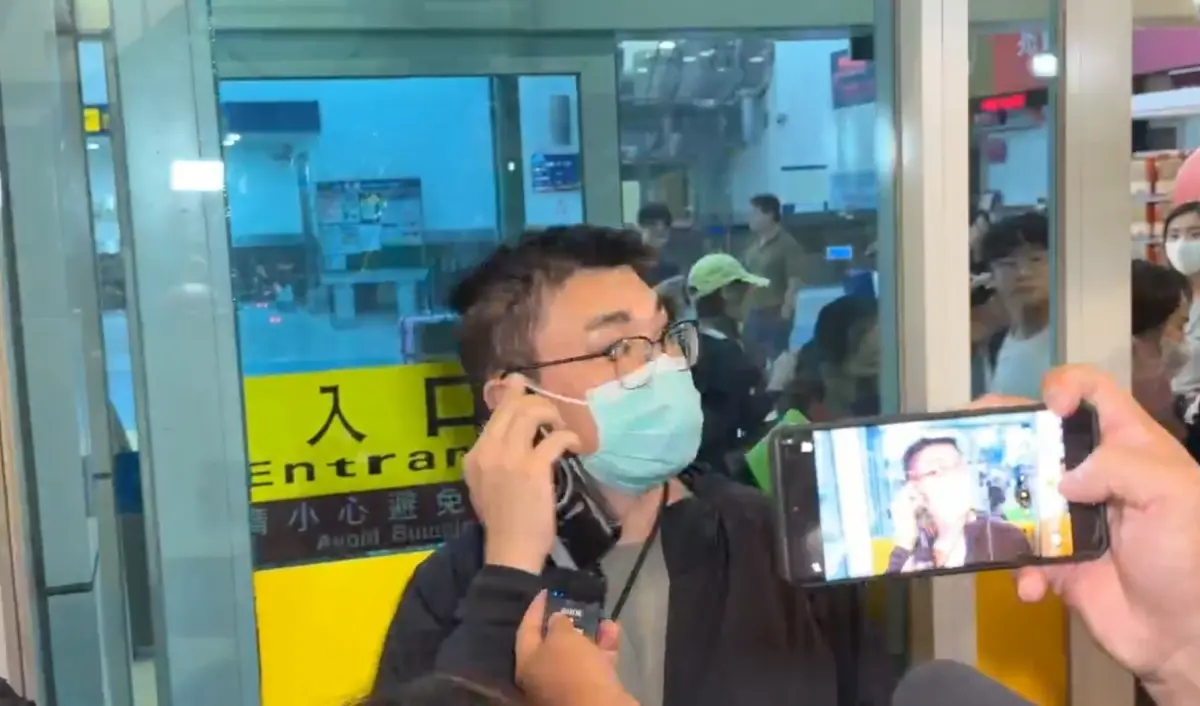 ▲趙建銘深夜飛抵高雄小港機場，面對媒體守候，幾乎全程噤聲！僅示意媒體請看離婚協議第8條，違約要賠懲罰性金額1億元。（圖／讀者提供）