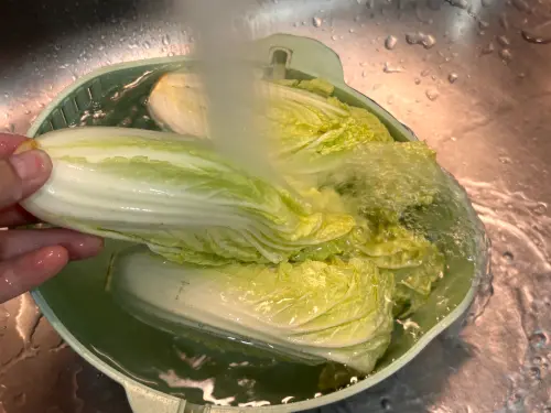 ▲洗菜第一步：先不切根，用流動自來水預沖整株娃娃菜約 10 秒洗去表面灰塵。（圖／記者徐銘穗攝）