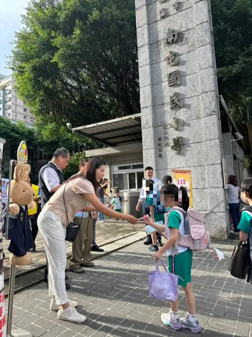 ▲侯湘婷（穿白褲彎腰者）一起跟到校的學童宣導犯罪，預防、交通安全與婦幼安全觀念，並一一跟學童和家長打招呼。（圖／翻攝自臺中第四波麗士臉書）