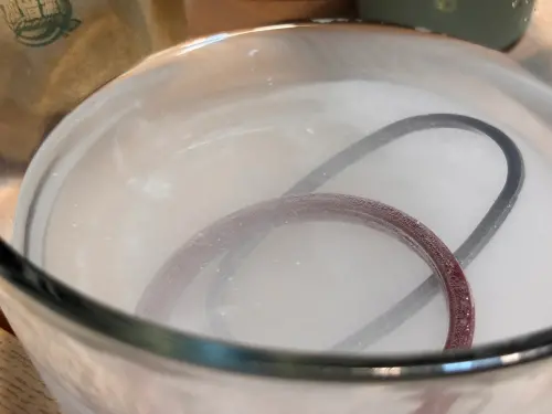 ▲過碳酸鈉溶於溫水後會釋放活氧細小氣泡，徹底包覆矽膠圈深層去霉殺菌。（圖／記者徐銘穗攝）