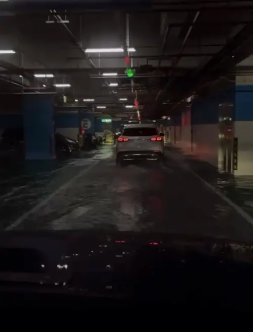 ▲台北今日受到低壓帶及不穩定天氣影響，降雨明顯，南港火車站地下3樓停車場傳出嚴重積水，車輛通行時甚至濺起水花。（圖／翻攝自Threads@coder.isme）